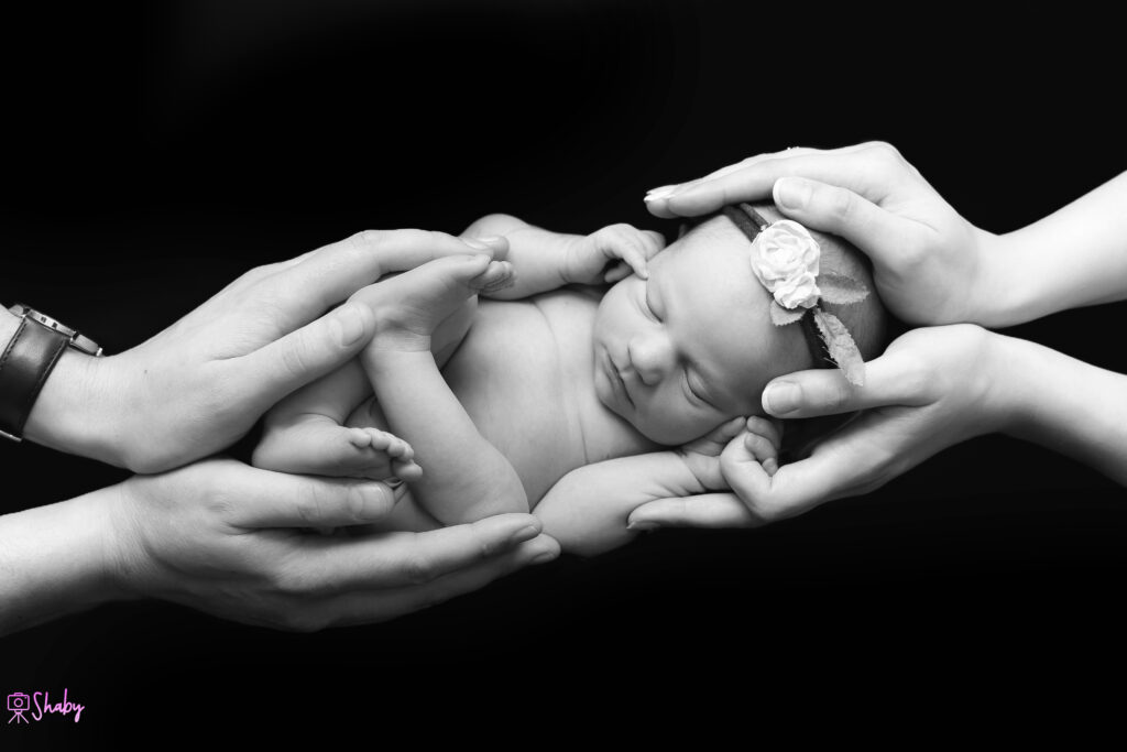 Newborn baby girl Nora sleeping peacefully with a gentle smile, during a professional photography session in Ireland.